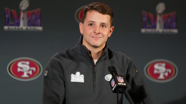 Brock Purdy stands at a microphone in Las Vegas